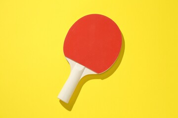 One ping pong racket on yellow background, top view