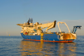 Offshore DP3 Cable Laying Vessel Deploying Subsea Cable Next To Substation Installation During Wind...