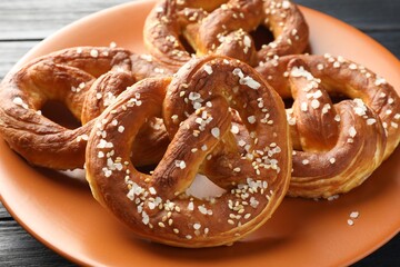 Tasty pretzels with salt on table, closeup
