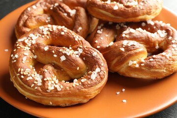 Tasty pretzels with salt on table, closeup