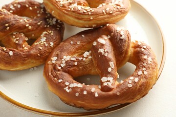 Tasty pretzels with salt on white table, closeup