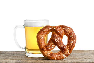 Tasty pretzel and glass of beer on wooden table against white background