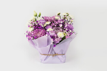 Bouquet of different purple flowers as a gift, white background. Gift for a holiday, Women's Day, Wedding, Mother's Day, March 8.