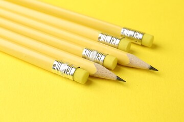 Many graphite pencils on yellow background, closeup