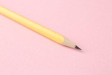 One graphite pencil on pink background, closeup