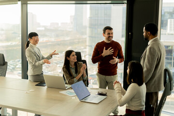 Team collaborates in modern office setting on innovative project with laptops and discussion