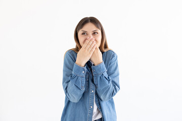 Happy woman closing her mouth with hands going to see surprise prepared by husband or having tricky plans. Young cheerful lady covering face with hands