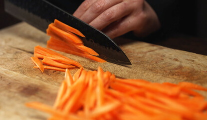 Female Chef Slicing Carrots into Julienne Strips.