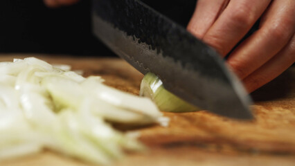 Female Chef Slicing Onion on Wooden Cutting Board.