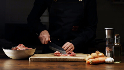 Female Chef Cutting Chicken Thighs with Knife.