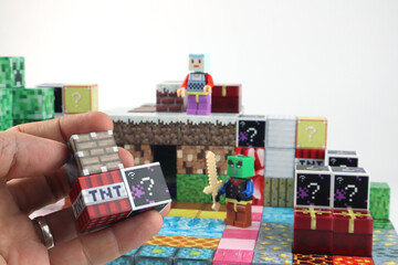 Naklejka premium Minecraft magnetic building toy blocks , from online virtual world game series are display on white table with many kinds of Mine craft blocks , tnt magma stone wood grass water and cute characters