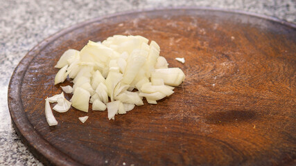 chopped onion on top of a wooden cutting board