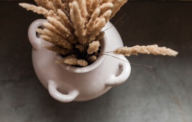 Artisanal ceramic home decor in a minimalist showroom. Handcrafted vases, candle holders, and tableware in earth tones. Includes Easter-themed ceramics and in-store workshop scenes