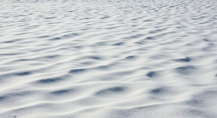 Rippled snow surface creating a textured winter landscape, a blanket of white covering the ground with wavy patterns and cold, icy ridges in a natural outdoor scene.