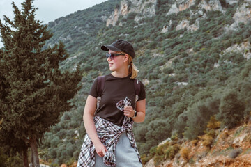 Travel,Young female traveler walking alone alongscenic mountain road solo travel, digital nomad lifestyle, eco-friendly road trip adventure.moment of mindful journeyexploration in nature.