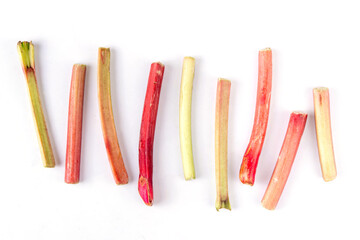 Raw fresh organic rhubarb stems on white background, bunch of homegrown pink and green rhubarb ready for cooking dish, dessert or jam. Summer harvest, cooking ingredient