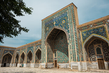 Colorful facade of Islamic madrasa with intricate geometric mosaics and traditional oriental...