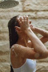 young woman taking shower with wet hair under flowing water, natural light, clean skin, relaxing moment, bathroom interior, fresh and calm atmosphere