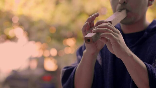 Indigenous man playing Andean instrument at an outdoor festival