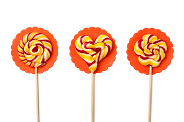 Three large lollipops on a stick in the shape of a circle, a flower and a heart on white background, handmade