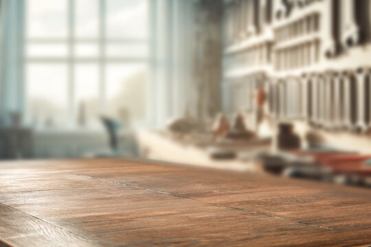 Wooden table in front of a blurred background of a carpenter&rsquo;s workshop. Great for promoting handmade products, tools, or DIY content.