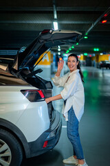 Woman parking in car park and packing into her car's trunk