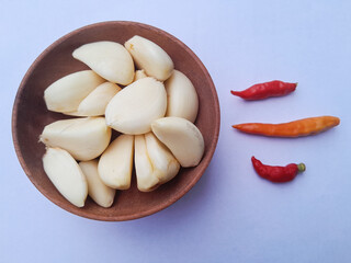 Bawang putih kupas. Peeled garlic isolated on white background. Perfect for design elements, or any commercial purposes. On a wooden bowl.