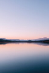 Fototapeta premium glassy lake reflects pastel sky at dawn light creating serene and minimalistic image with ample copy space