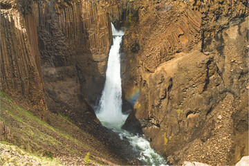 Litlanesfoss waterfall cascades between basalt columns in East Iceland...