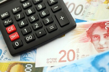 Israel New Shekels banknotes and calculator. The current Israel money bills and calc lies on table