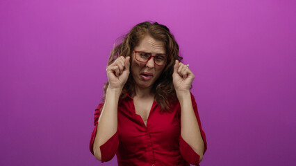 Woman expressing disgust over an isolated pink background wall with glasses showing emotion through...