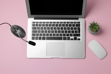 Professional microphone, laptop, mouse and floral decor on pink background, flat lay