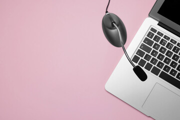 Professional microphone and laptop on pink background, flat lay. Space for text