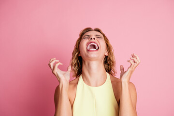 Adorable woman in yellow dress expressing joy and vivacity against bright pink backdrop,...