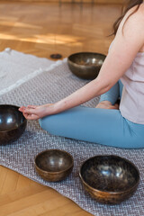 Sound healing ceremony in a yoga studio with Tibetan singing bowls, incense, and meditating...