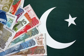 Pakistan rupees banknotes on Pakistani flag background. The current Pakistan money bills
