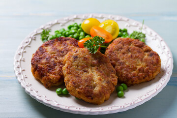 Fish cakes with green peas. Fish patties or burgers. View from above, top studio shot
