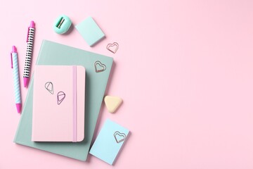 Pens and other stationery on pink background, flat lay. Space for text