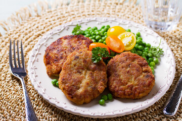 Fish cakes with green peas. Fish patties or burgers. View from above, top studio shot