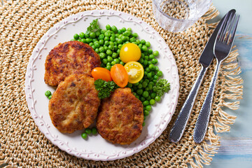 Fish cakes with green peas. Fish patties or burgers. View from above, top studio shot
