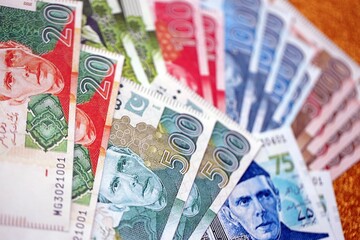 Pakistan rupees banknotes on golden yellow background. The current Pakistan money bills