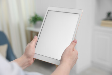 Naklejka na ściany i meble Woman with modern tablet at home, closeup