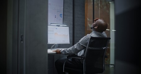 Financial Analyst Suffering from Financial Crisis, Yelling During Call, Analyzing Exchange Market Charts in Office at Night. African American Businessman Furious About Sudden Stock Market Collapse.
