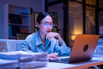Working Asian women feel stressed,tired from work,migraine headaches from hard work while working and overtime in office at night