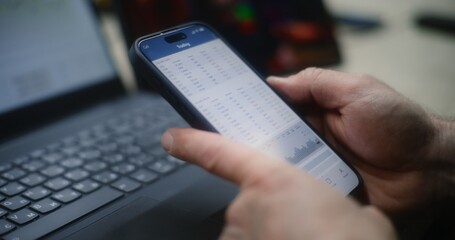 Man Checking Real-Time Stocks and Exchange Market Charts on Smartphone and Laptop, Watching Online Trading Lesson on Tablet. Employee Making Investments During Working Hours in Workshop. Close Up.