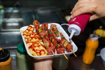 Delicious Street Food Skewers and Fries Served in Styrofoam Tray