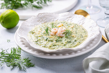 Creamy vegetable soup with shrimps and herbs