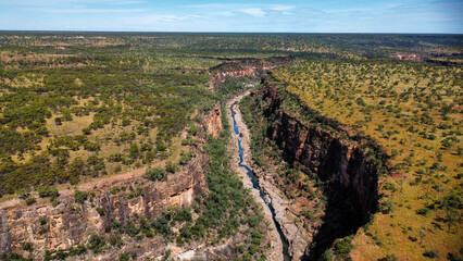 A calm creek flowing through a canyon in the Australian outback, seen from above