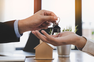 Realtor agent giving a key of apartment to new owner after signed lease agreement.