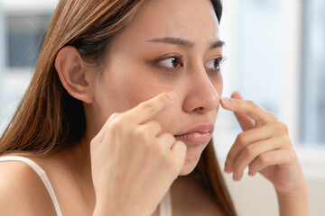 lack of sleep problem, Worried Asian young woman pointing finger at dark circles under her eyes